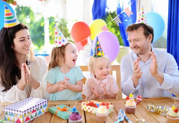 Niedliche kleine Kinder Zwillinge und ihre Eltern haben Spaß und feiern Geburtstagsparty mit bunten Dekoration — Stockfoto