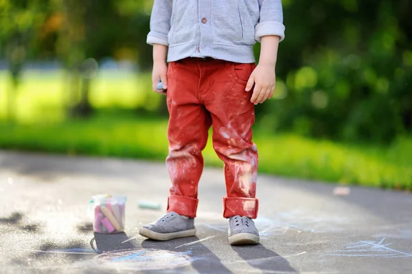 Close-up photo of little kid boy drawing with colored chalk on asphalt — Stock Photo, Image