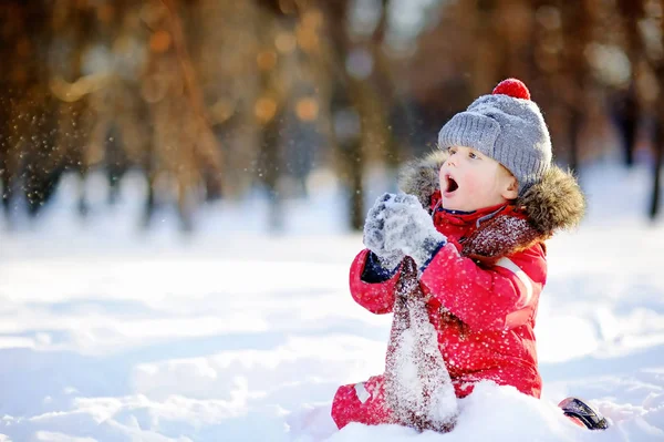 Niño con ropa roja de invierno divirtiéndose con nieve — Foto de Stock