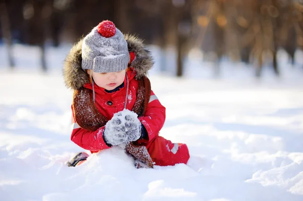 Little boy in red winter clothes having fun with snow — Stock Photo, Image