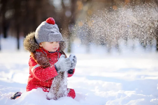 Niño con ropa roja de invierno divirtiéndose con nieve — Foto de Stock