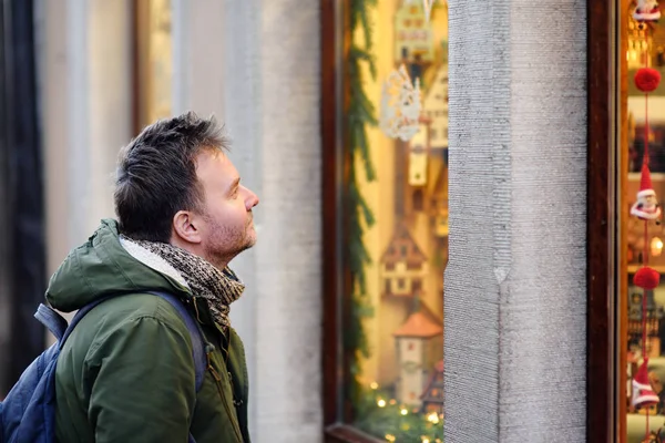 Medelålders man ser på Xmas leksaker och tillbehör på traditionell julmarknad i Bayern, Tyskland. — Stockfoto