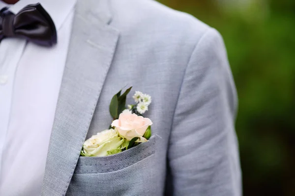 Λεπτομέρειες του κοστούμι γαμπρού: μπουτονιέρα από φρέσκο λευκό τριαντάφυλλο και κομψό παπιγιόν — Φωτογραφία Αρχείου