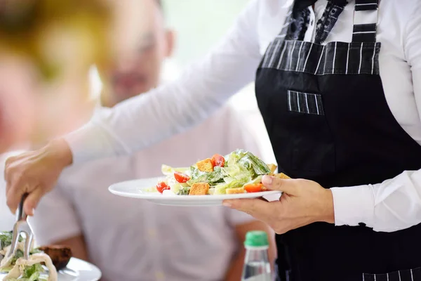 Ober uitoefening platen met salade van partij of bruiloft receptie — Stockfoto