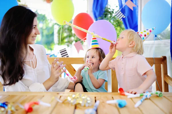 Kleine Kinder und ihre Mutter feiern Geburtstagsparty mit bunter Dekoration und Kuchen mit bunter Dekoration und Kuchen — Stockfoto