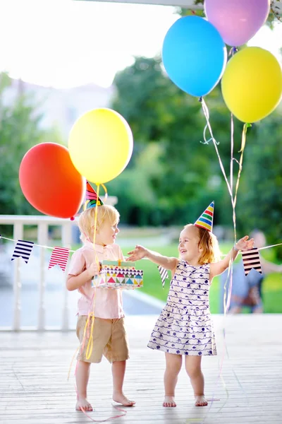 Niño y niña se divierten y celebran fiesta de cumpleaños con globos de colores — Foto de Stock