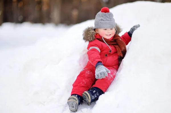 Kleiner Junge in roter Winterkleidung amüsiert sich mit Neuschnee — Stockfoto