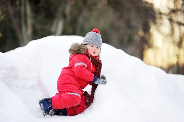 Piros téli ruhákat, birtoklás móka-val friss hó kisfiú — Stock Fotó