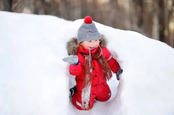 穿红色冬衣的小男孩用新鲜的雪玩 — 图库照片