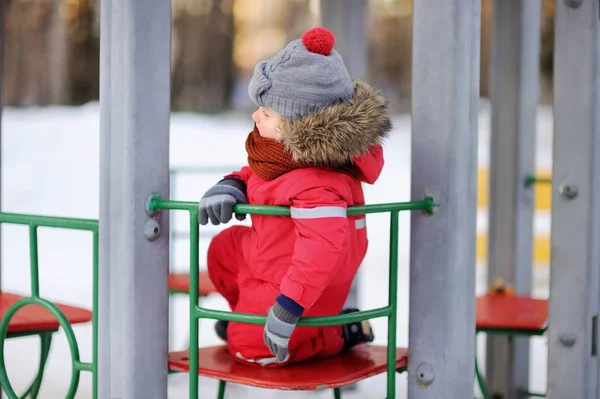 Niño en ropa de invierno rojo divertirse en el patio al aire libre — Foto de Stock
