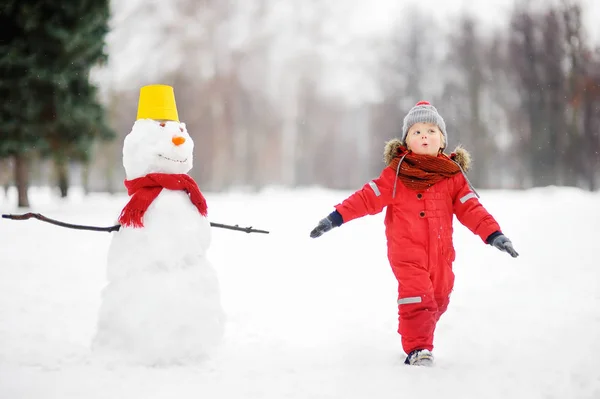 Criança durante um passeio em um parque de inverno nevado — Fotografia de Stock