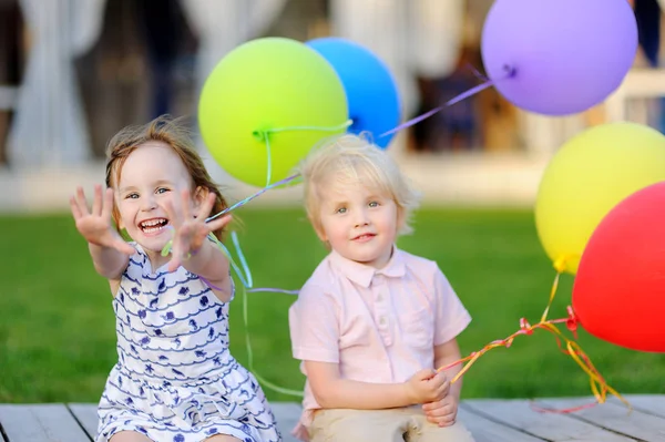 Menino e menina se divertindo e celebrar a festa de aniversário com balões coloridos — Fotografia de Stock
