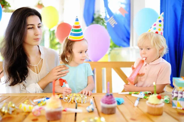 Маленька дитина та їх мати святкують день народження з барвистими прикрасами та тортами з барвистими прикрасами та тортами — стокове фото