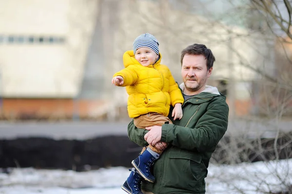 Middle age father with his little son together outdoors. Fatherhood concept