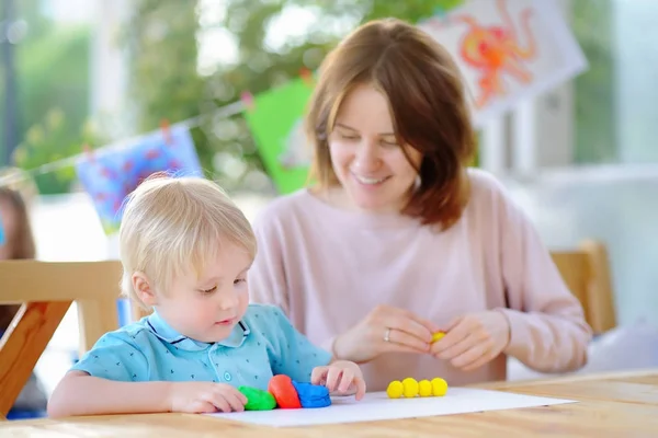 Cute little boy drawing and painting with colorful markers pens at kindergarten — Stock Photo, Image