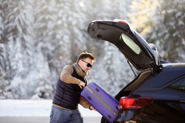 Yakışıklı adam için tatil, onun araba çizme bavul ile yükleme
