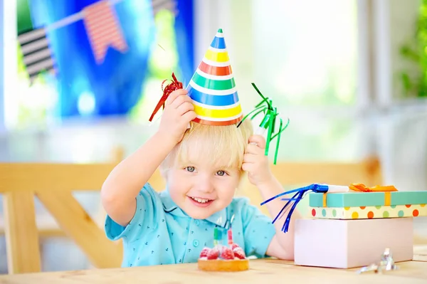 Милый мальчик веселится и праздновать день рождения с красочным украшением и торт — стоковое фото