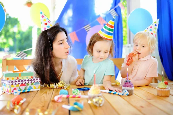 Pequeño niño y su madre celebran fiesta de cumpleaños con decoración colorida y pasteles con decoración colorida y pastel — Foto de Stock