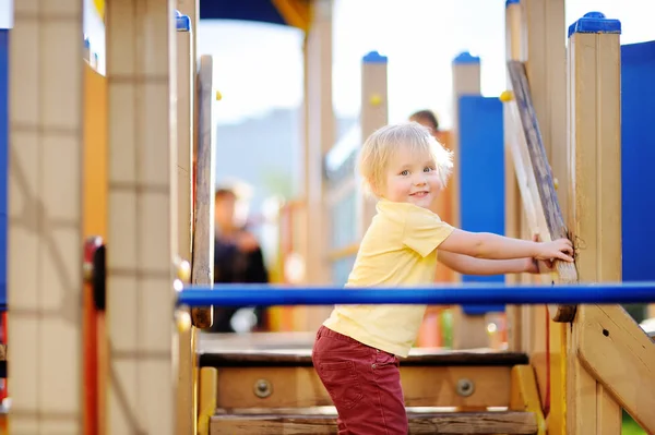 Маленький хлопчик розважається на відкритому майданчику / слайді — стокове фото