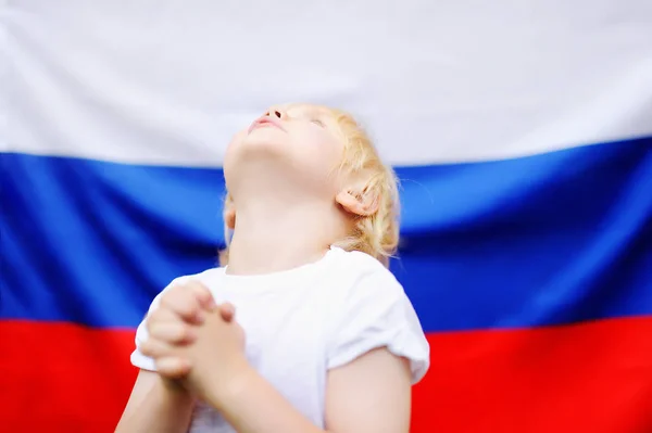 Портрет эмоционального мальчика с российским флагом на заднем плане — стоковое фото