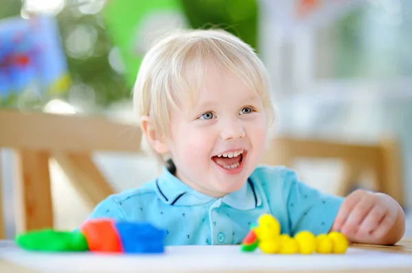 Creatieve jongen spelen met kleurrijke modellering clay op kleuterschool — Stockfoto