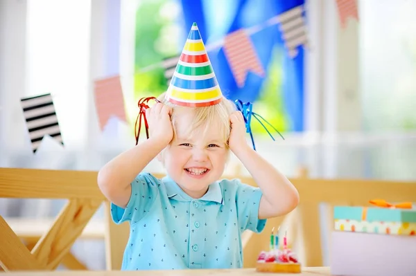 Lindo niño divirtiéndose y celebrar la fiesta de cumpleaños con decoración colorida y pastel — Foto de Stock