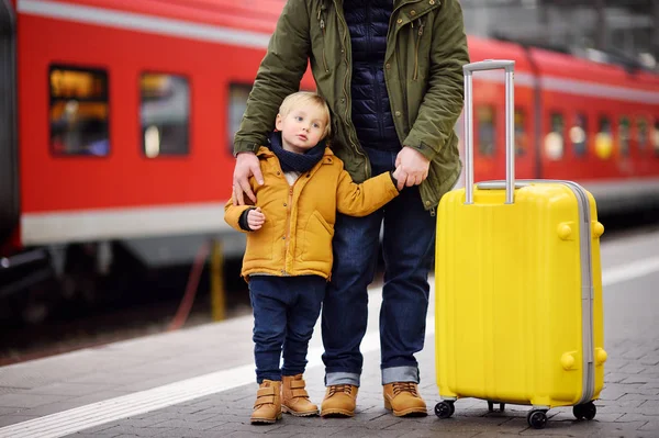 少年と彼の父親は鉄道駅プラットフォームを急行列車を待っています 冬の休暇 家族の概念 男と彼の息子を一緒に — ストック写真