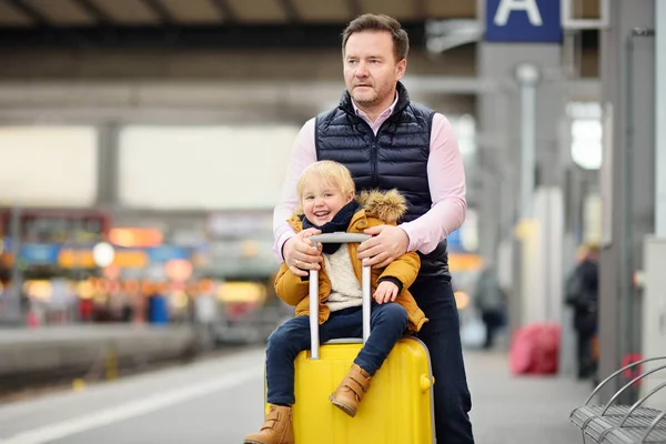 Carino bambino e suo padre in attesa treno espresso sulla piattaforma della stazione ferroviaria — Foto Stock