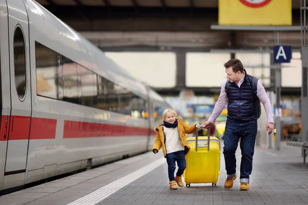 Cute little boy and his father waiting express train on railway station platform — Stock Photo, Image