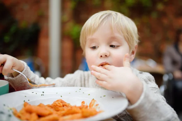 Ładny toddler chłopiec jedzenie makaron włoski pomieszczeniu restauracja — Zdjęcie stockowe