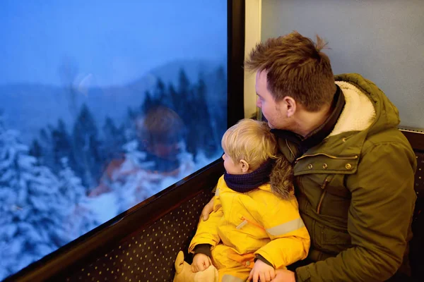 Familie kijken uit het raam van de trein tijdens de reis op tandrad spoorweg-/ tandradbaan in de bergen van de Alpen — Stockfoto