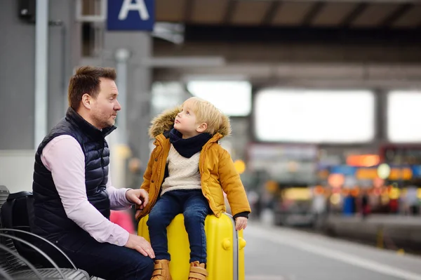 Cute little boy and his father waiting express train on railway station platform — Stock Photo, Image