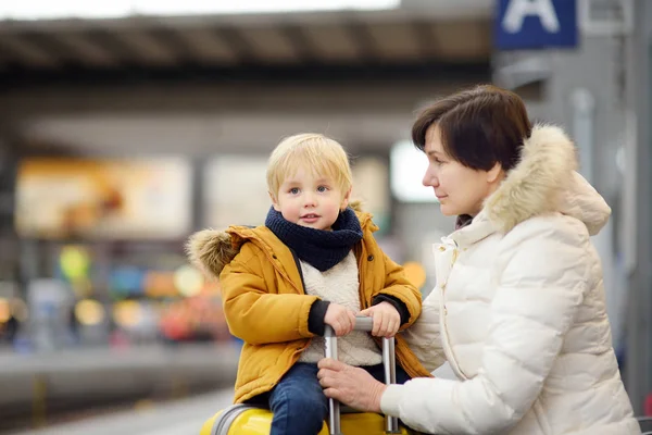 Cute little boy and his grandmother/mother waiting express train on railway station platform — Stock Photo, Image