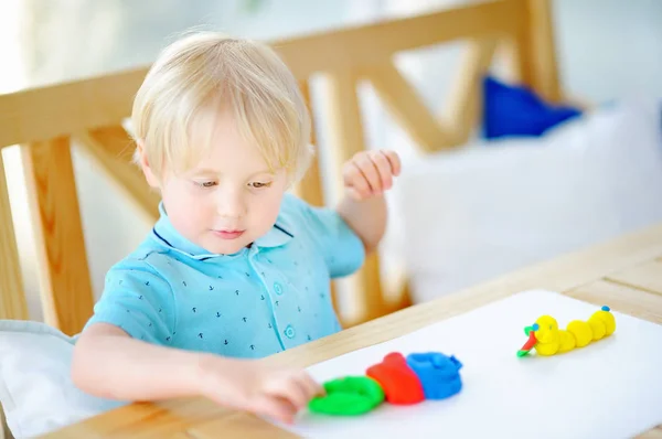 Menino criativo brincando com argila de modelagem colorida no jardim de infância — Fotografia de Stock