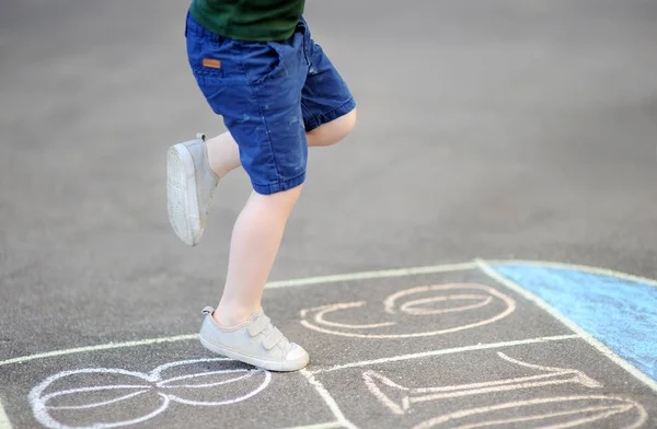 Kind spielt Hopscotch-Spiel auf Spielplatz im Freien an einem sonnigen Tag — Stockfoto