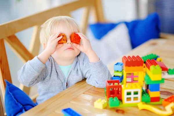 Malý chlapec hrát s barevnými plastovými bloky ve školce nebo doma — Stock fotografie