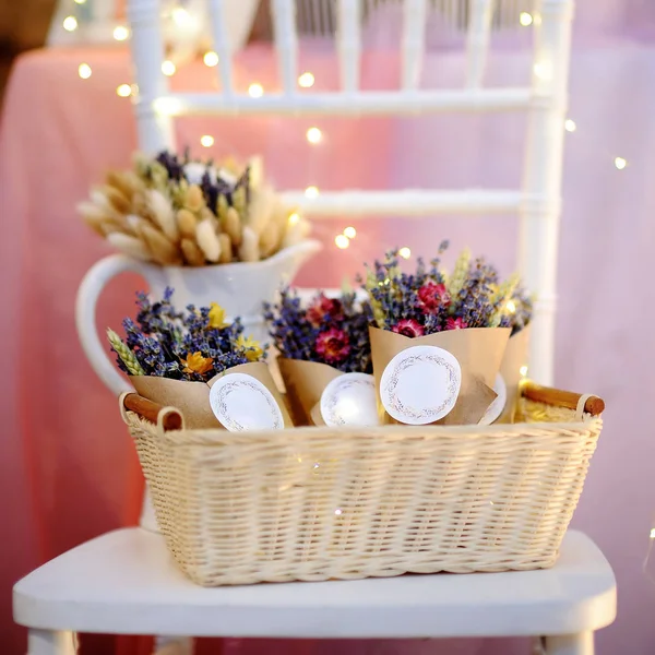 Prachtige gedroogde bloemen in papier doosjes met lampjes op de achtergrond — Stockfoto