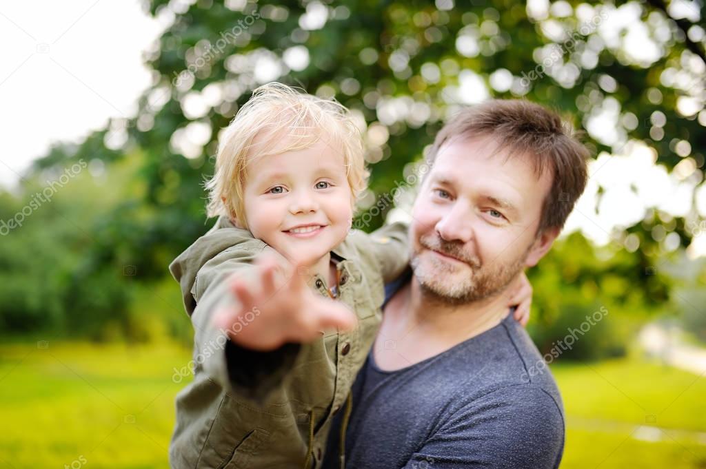 Middle age father with his little son having fun together outdoors