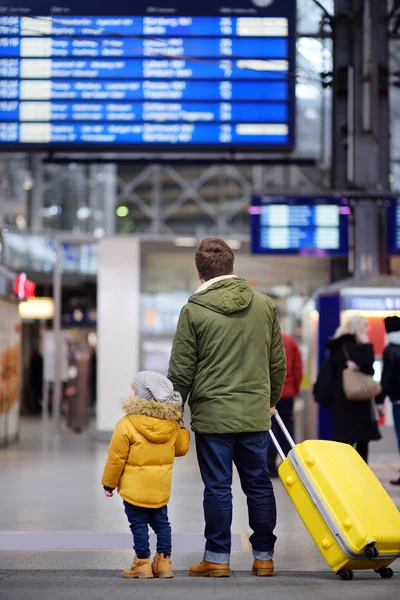 Menino e seu pai no aeroporto internacional ou na plataforma da estação ferroviária olhando para a exibição de informações — Fotografia de Stock