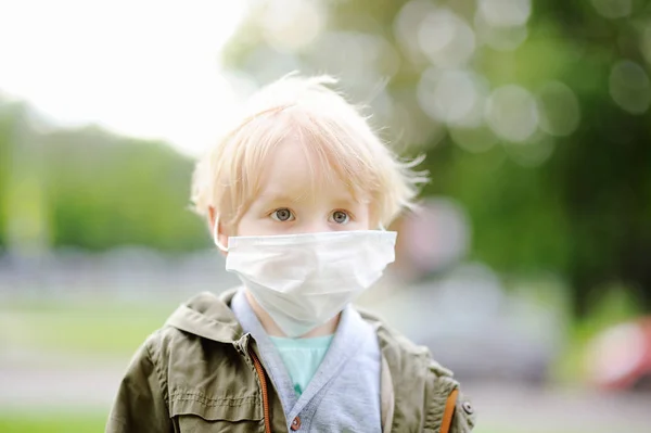 Liten pojke bär medicinsk ansiktsmask som skydd mot smittsamma sjukdomar — Stockfoto