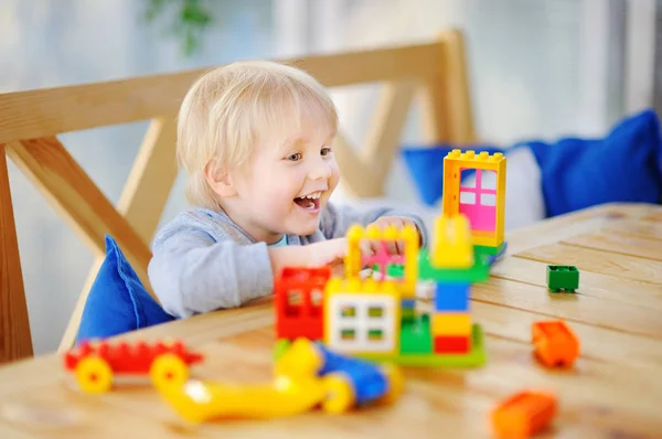 Niño jugando con bloques de plástico de colores en el jardín de infantes o en casa —  Fotos de Stock