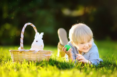 Paskalya yumurtası bahar Park için Paskalya gününde avcılık büyüleyici küçük çocuk
