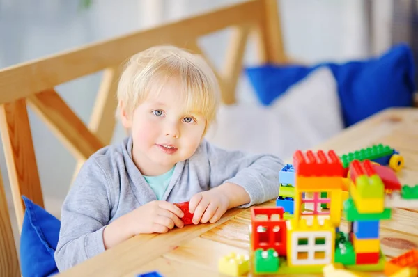 Niño jugando con bloques de plástico de colores en el jardín de infantes o en casa —  Fotos de Stock