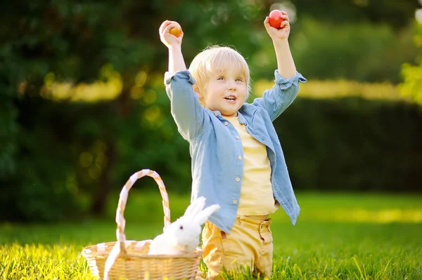 Okouzlující malý chlapec lov pro velikonoční vajíčko na jaře parku na velikonoční den — Stock fotografie