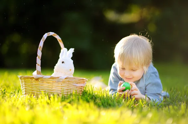 Encantador niño cazando huevos de Pascua en el parque de primavera en el día de Pascua — Foto de Stock