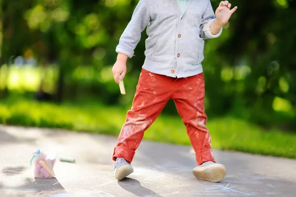 Foto de primer plano de niño pequeño dibujo con tiza de color sobre asfalto . —  Fotos de Stock