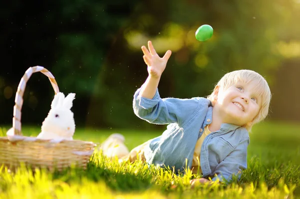 Charmanter kleiner Junge auf Ostereiersuche im Frühlingspark am Ostertag — Stockfoto