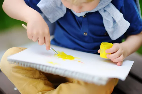 Milý chlapeček kreslení s barevnými laky v letním parku — Stock fotografie