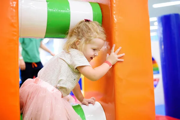 Krullend peuter meisje plezier in overdekte recreatie centrum voor kinderen. — Stockfoto