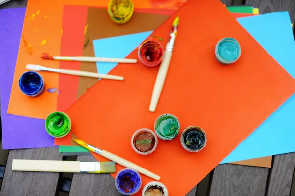 Peintures colorées, pinceaux et feuilles de papier — Photo